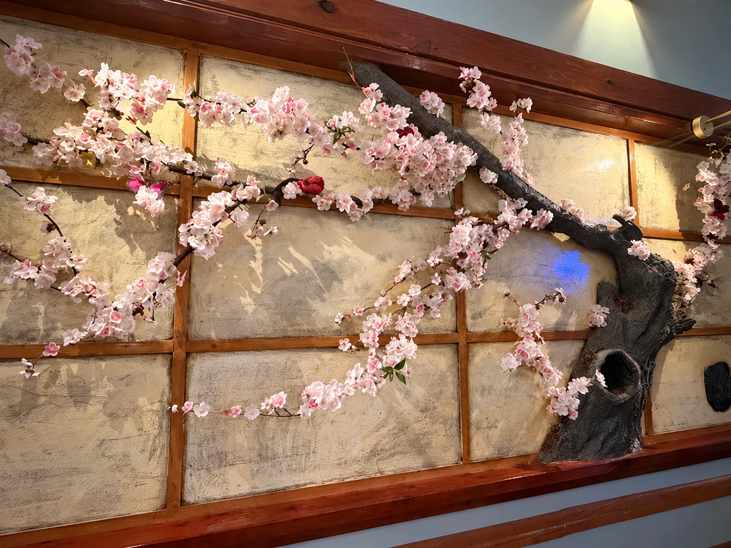 Cherry-blossom branches mounted along Midori’s wood-framed dining room wall